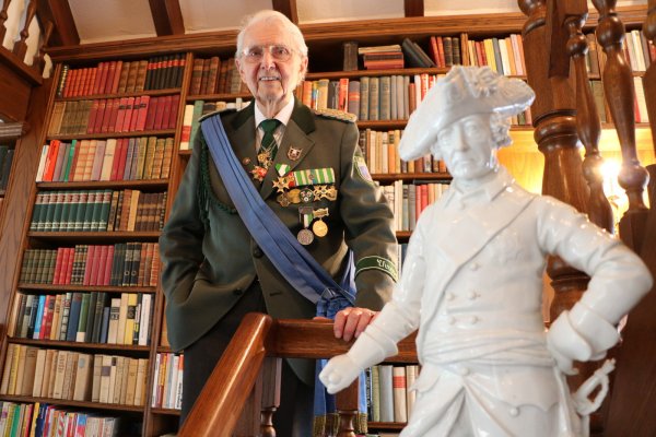 Geschichtsliebhaber: Otto Struck war 21 Jahre Oberst der Bad Salzufler Schützengesellschaft. Hier posiert er in seiner Uniform mit Friedrich dem Großen vor seinem Bücherregal. - © Yvonne Glandien