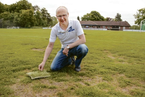 Möglicher Ersatz: Ralf Peterhanwahr mit einer kleinen Matte Hybridrasen auf dem löchrigen Sportplatz an der Berglage. - © TuS Viktoria Rietberg