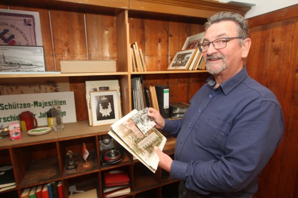 Noch lose Fotos: Ulrich Perlitius steht vor einem alten Schrank im historischen Rathaus. Die Archivgruppe hat dort bereits ganze Arbeit geleistet und Fotos und Schriftstücke sortiert und abgelegt. - © Daniel Hobein
