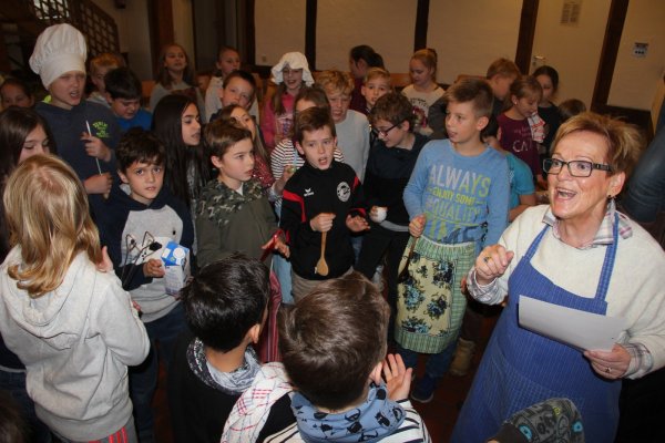 Zwischen den Kindern: Hannelore Budde übt mit den Grundschülern verschiedene Lieder wie „In der Weihnachtsbäckerei" auf Lippisch Platt ein. Dabei haben alle viel Spaß und es wird sich auch verkleidet. - © Iris Liebig