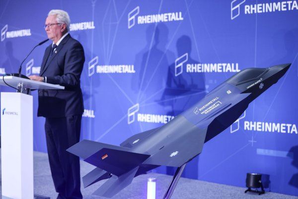 Ein Modell des F-35 auf der Bühne, auf der Konzernchef Papperger zu Mitarbeitern spricht. - © Oliver Berg/dpa