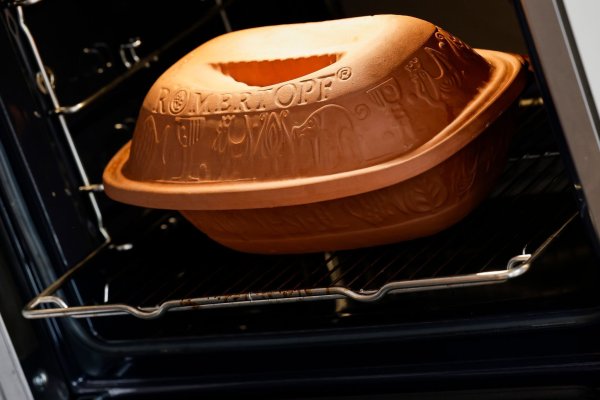 Ein Römertopf steht in einem Backofen. - © Daniel Löb/dpa/Symbolbild