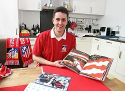 Mit Atl&eacute;tico am K&uuml;chentisch: Andr&eacute; Kahle zeigt den Bildband von der 100-Jahr-Feier seines Lieblingsvereins. - &copy; Foto: Hagemann