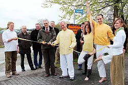 Bürgermeister Eberhard Block und Yoga Vidya-Leiter Volker Bretz (Mitte) zerschneiden gemeinsam das Band. - © Foto: Gröne