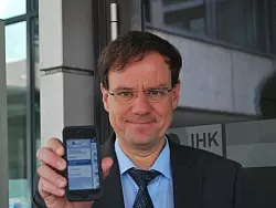 Swen Binner, Gesch&auml;ftsf&uuml;hrer der IHK Ostwestfalen, pr&auml;sentiert die App auf seinem Smartphone. - &copy; FOTO: LEONIE MOLLS