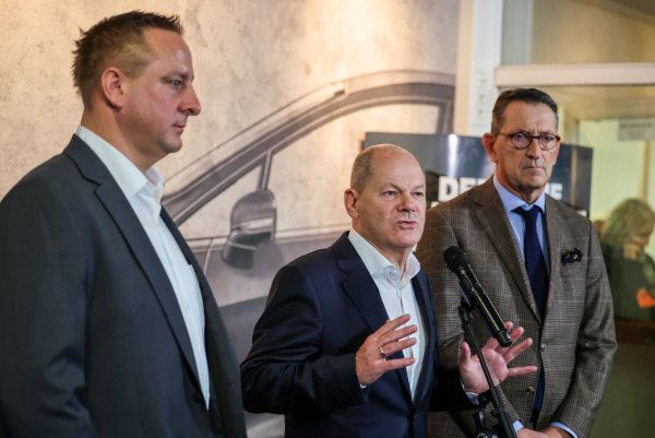 Betriebsratschef Benjamin Gruschka (l) neben Bundeskanzler Olaf Scholz (SPD) und Marcus Wassenberg (r), Geschäftsführer der Ford-Werke. - © Christoph Reichwein/dpa