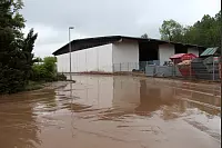 Auf der Industriestraße in Humfeld stehen zentimeterhoch Wasser und Schlamm. Auch die anliegenden Firmen sind betroffen. - © Nadine Uphoff