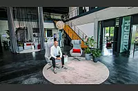 Tino J. Röse ist der Kopf von "emotions4life". Vor 15 Jahren gründet er das Unternehmen und arbeitet sich Jahr für Jahr immer weiter an die Spitze seiner Branche hoch. Hier sitzt er in der „Media Gallery“, die gleich mehrere Hingucker zu bieten hat – darunter ein von der Decke hängender Vorhang, der sich elegant um eine Sofalandschaft windet. - © Daniel Salmon