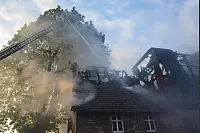 Brand "Zur Alten Wasserm&uuml;hle, Kalletal-Langenholzhausen
Hier werden die Dachpfannen von der Drehleiterbesatzung vom Dach "gespritzt", um die L&ouml;scharbeiten zu erleichtern. - &copy; Foto: Watermann
