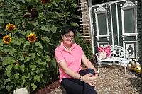 Gerlinde Kersting hat ihren großen Garten komplett selbst gestaltet. Die Delbrückerin baut auch so etwas wie die fast 200 Jahre alte Haustür hinter ihr mit ein. - © Uwe Müller
