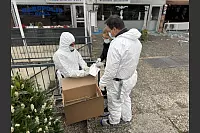 Ermittler der Polizei und der Spurensicherung bei der Tatortaufnahme. In dem Karton sammeln sie relevante Spuren. - © Paul Brinkmann