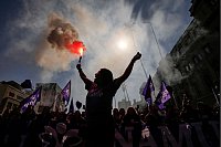 Eine Frau hält am Internationalen Frauentag eine Fackel in Santiago de Chile. - © Esteban Felix/AP/dpa