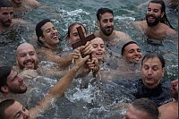 Schwimmer holen bei den orthodoxen Feierlichkeiten zur Segnung des Wassers am Princess Pier das "Heilige Kreuz" aus dem Wasser. Derjenige, der es zuerst holt, soll für ein Jahr gesegnet sein. - © Joshua Stanyer/SOPA Images via ZUMA Press Wire/dpa