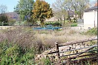 Neubau geplant: Noch wächst Gras und die landwirtschaftliche Geräte stehen auf dem freien Gelände. Hier soll der neue Schweinemaststall mit 936 Plätzen entstehen. Er wird mit dem alten Stall (rechts im Bild) verbunden. - © Foto: Strathmann