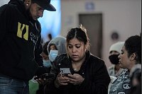 Lateinamerikanische Migranten beobachten die Amtseinführung von US-Präsident Trump in der Unterkunft Juventud 2000 in Tijuana. - © Felix Marquez/dpa