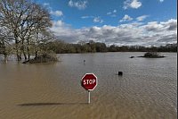 Land unter: Ein Verkehrsschild ragt aus dem Wasser in einer überschwemmten Straße im Westen Franckreichs. - © Thibault Camus/AP/dpa