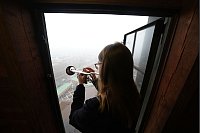 Neue Töne über Hamburg: Neele Fokken, neue Türmerin am Hamburger Michel, spielt den Türmer-Choral auf dem Türmerboden der Hauptkirche St. Michaelis. Fokken wird sich als erste Frau die Position mit dem langjährigen Hamburger Türmer Josef Thöne teilen. - © Marcus Brandt/dpa