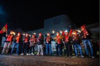 Mitarbeiter von Volkswagen stehen mit Fackeln vor dem VW Werk in Osnabrück. Die IG Metall hat ihre Mitglieder in der Metall- und Elektroindustrie zu flächendeckenden Warnstreiks aufgerufen. - © Guido Kirchner/dpa