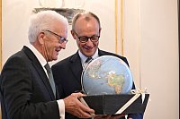 Kretschmann schenkte Merz einen Globus - weil ein Kanzler ja auch Weltpolitik mache. - © Marijan Murat/dpa