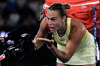 Australian Open: Aryna Sabalenka schreibt nach ihrem Sieg ein Autogramm auf eine Fernsehkamera - © Ng Han Guan/AP/dpa