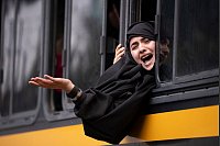 Eine Frau der extremistischen ultra-orthodoxen jüdischen Sekte Lev Tahor ruft aus einem Bus in Guatemala-Stadt anderen Mitgliedern auf der Straße etwas zu. - © Santiago Billy/AP/dpa