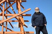 «Purple Path»-Kurator Alexander Ochs steht an der Arbeit «Zwei in einander Gewobene» des Konzeptkünstlers Olaf Holzapfel in Amtsberg. Das Gros der Kunstwerke an dem Kunst- und Skulpturenweg bleibt über das Jahr 2025 in der Region erhalten. (Archivbild) - © Hendrik Schmidt/dpa