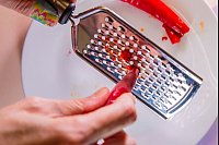 Die gefrorene Chilischote lässt sich leichter reiben und spritzt dabei weniger. - © Christin Klose/dpa-tmn