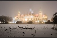 Das Neue Rathaus wird am frühen Morgen bei Nebel und Temperaturen unter dem Gefrierpunkt illuminiert, während eine dünne Eisschicht den Maschteich in Hannover bedeckt. - © Julian Stratenschulte/dpa