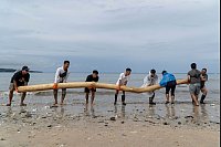 Jetzt wird aufgeräumt: Freiwillige entfernen einen Baumstamm, der von den saisonalen Monsunfluten an Land gespült wurde, während einer Strandsäuberungsaktion am Kedonganan Strand auf der Ferieninsel Bali. - © Dicky Bisinglasi/AP/dpa