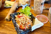 Eine Teilnehmerin hat unter Anleitung ein Som Tam hergestellt - typischen grünen Papaya-Salat mit Chilis und Erdnüssen. - © Carola Frentzen/dpa-tmn