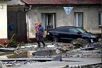 Nach den verheerenden Überschwemmungen in Tschechien laufen die Anwohner durch die zerstörte Straße - © Petr David Josek/AP