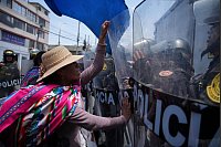 Eine Frau, die in Peru gegen die Regierung protestiert, drückt gegen Schutzschilder von Polizisten, die den Gipfel der Asiatisch-Pazifischen Wirtschaftsgemeinschaft (APEC) schützen. - © Guadalupe Pardo/AP