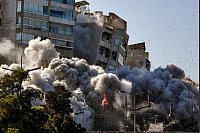 Rauch und Staub steigt auf, als ein Gebäude einstürzt, nachdem es bei einem israelischen Luftangriff in Tajuna, einem Vorort der libanesischen Hauptstadt, getroffen wurde. - © Marwan Naamani/ZUMA Press Wire/dpa