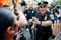 Ein New Yorker Polizist versucht Demonstranten während einer pro-palästinensischen Demonstration aufzuhalten. - © Stefan Jeremiah/AP/dpa
