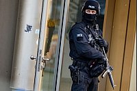 Ein Polizist steht mit einer Maschinenpistole in Duisburg. Bei einer Attacke in einem Fitnessstudio in der Innenstadt sind mehrere Personen schwer verletzt worden. - © Christoph Reichwein/dpa