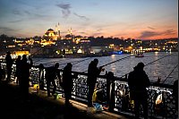 Angler in Istanbul fischen nach frischem Fisch bei Sonnenuntergang auf der Galata-Brücke über den Bosporus. - © Francisco Seco/AP/dpa