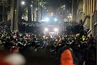 Die Polizei blockiert Demonstranten vor dem Parlamentsgebäude in Tiflis. - © Zurab Tsertsvadze/AP/dpa