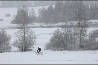 Ein Radfahrer fährt durch die schneebedeckte Landschaft in Bayern. - © Karl-Josef Hildenbrand/dpa