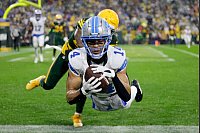 Detroit Lions Wide Receiver Amon-Ra St. Brown (14) fängt einen Touchdown vor Green Bay Packers Cornerback Keisean Nixon (25). - © Matt Ludtke/AP/dpa