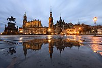 Dresden am Abend - Das Reiterstandbild König Johann (l-r), die Hofkirche, der Hausmannsturm, das Residenzschloss und die Schinkelwache spiegeln sich am Abend in einer Pfütze auf dem Theaterplatz. - © Robert Michael/dpa