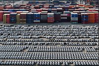 Neue Volvo-Fahrzeuge stehen neben Containern und warten auf ihre Verschiffung im Jangtse-Hafen in der Stadt Nanjing in der ostchinesischen Provinz Jiangsu. - © Uncredited/CHINATOPIX/AP/dpa