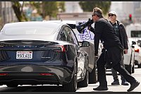 Demonstranten belästigen einen Tesla-Fahrer während einer Kundgebung vor einem Tesla-Händler in San Francisco. - © Josh Edelson/AP/dpa