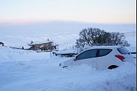 Schneemobil: Ein Auto steckt in Großbritannien in Northumberland im Schnee. - © Owen Humphreys/PA Wire/dpa