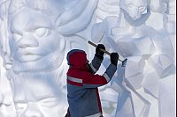 Ein Künstler arbeitet im chinesischen Harbin während eines Festivals, auf dem Schneeskulpturen gezeigt werden, an einem Kunstwerk aus Schnee und Eis. - © Andy Wong/AP/dpa