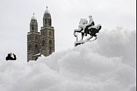 Schnee in der Schweiz: Ein Mann fotografiert das Großmünster in Zürich. - © Ennio Leanza/KEYSTONE/dpa