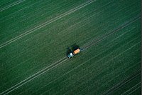 Landwirtschaftstag in Mecklenburg-Vorpommern - Mit einem Traktor zieht ein Landwirt einen Düngerstreuer zum Beginn der Agrarsaison über einen Acker. - © Jens Büttner/dpa