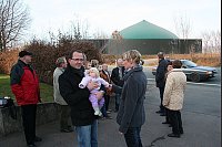 Ein Teil der Nachbarschaft diskutiert auf dem Grundstück der Familie Plöger (im Vordergrund Marion und Dag Plöger sowie die kleine Leonie) über das Großprojekt, das direkt an der Ostwestfalenstraße (siehe Montage im Hintergrund) entstehen soll. - © Montage: Wenzel/Foto: Reineke