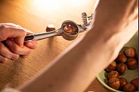 Schritt 3: Knoblauchpresse öffnen und Nuss herausnehmen. - © Christin Klose/dpa-tmn