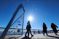 Frühlingserwachen an der Ostsee: Bei strahlendem Sonnenschein und blauem Himmel sind Spaziergänger in Haffkrug in Schleswig-Holstein an der Ostsee unterwegs. - © Christian Charisius/dpa