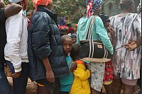 Menschen stehen an, um in einer Unterkunft für Familien, die durch Bandengewalt in Haiti vertrieben wurden, in Port-au-Prince Lebensmittel zu erhalten. - © Odelyn Joseph/AP/dpa